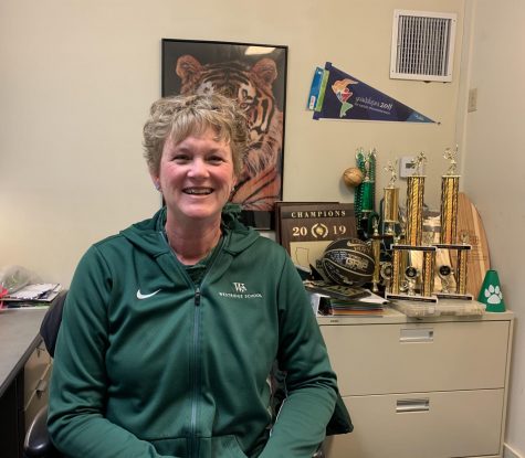 Coach Horn in her office full of athletic trophies
