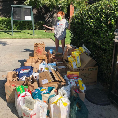 Mia G. ‘25 standing in front of piles of donated breakfast cereal 
