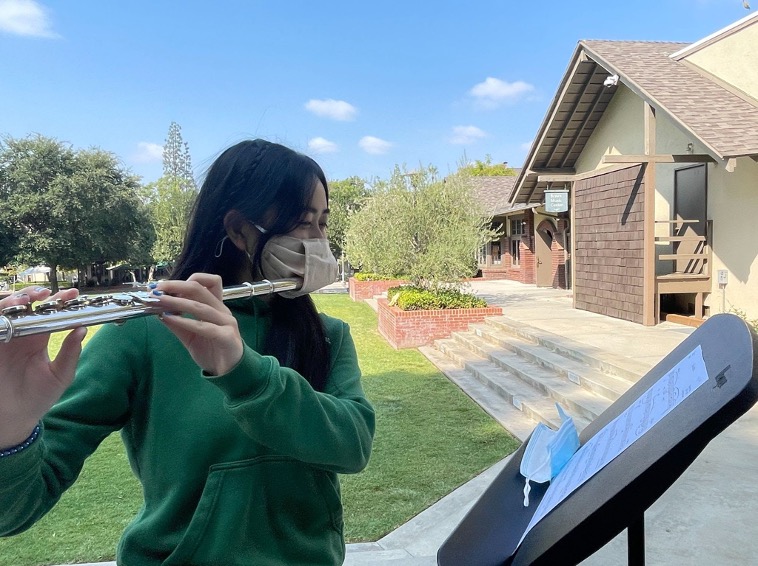 Outside of Braun, Crystal Z. ’23 plays her flute with her specialized masks. 