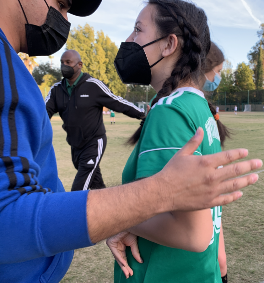 Coach Fernando Chaves prepares Holly N. '25 before she enters the field.