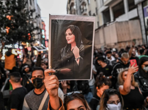 A protester holds a portrait of Mahsa Amini during a demonstration in support of Amini. 