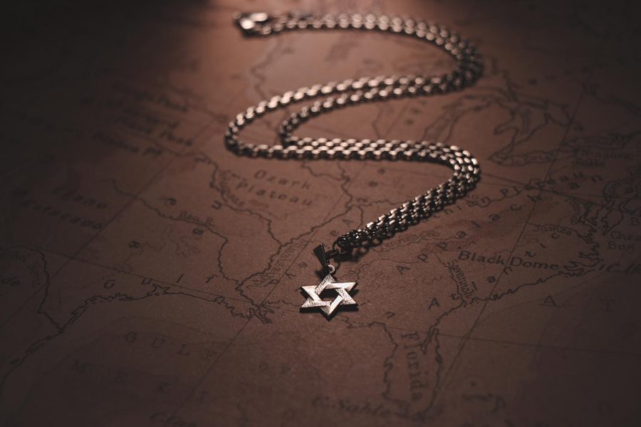 A magen david (Star of David) necklace lays along a map of the United States of America. Recently, antisemitism in the States has been on an upward trent.