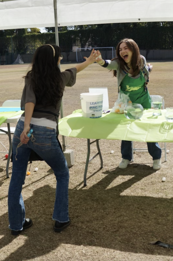 A booth offering games at SOF—featuring two sprightly volunteers mid-high-five because thats what community is all about.