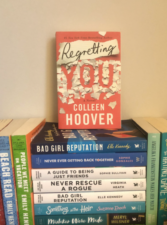 A picture of my copy of Regretting You by Colleen Hoover amongst other romance books.