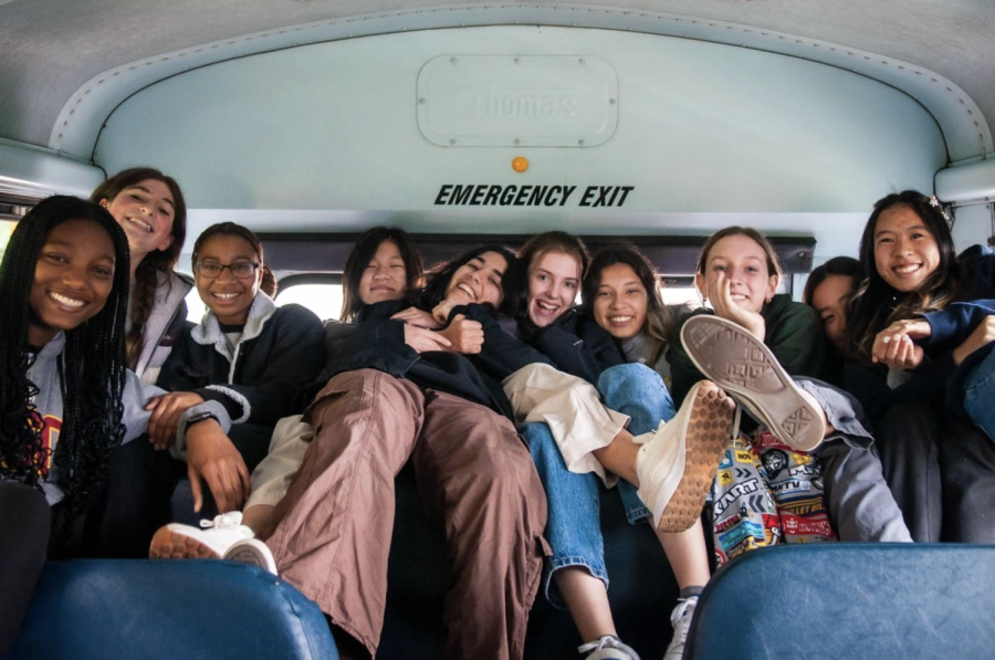 Students pose for a picture in the back of the bus. (Photo Credit: Katie L. ’27)