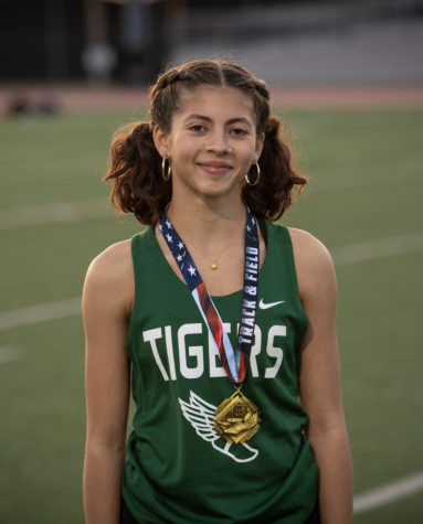Freshman Teia L. smiles with her gold medal after winning pole vault at the Prep League Finals.