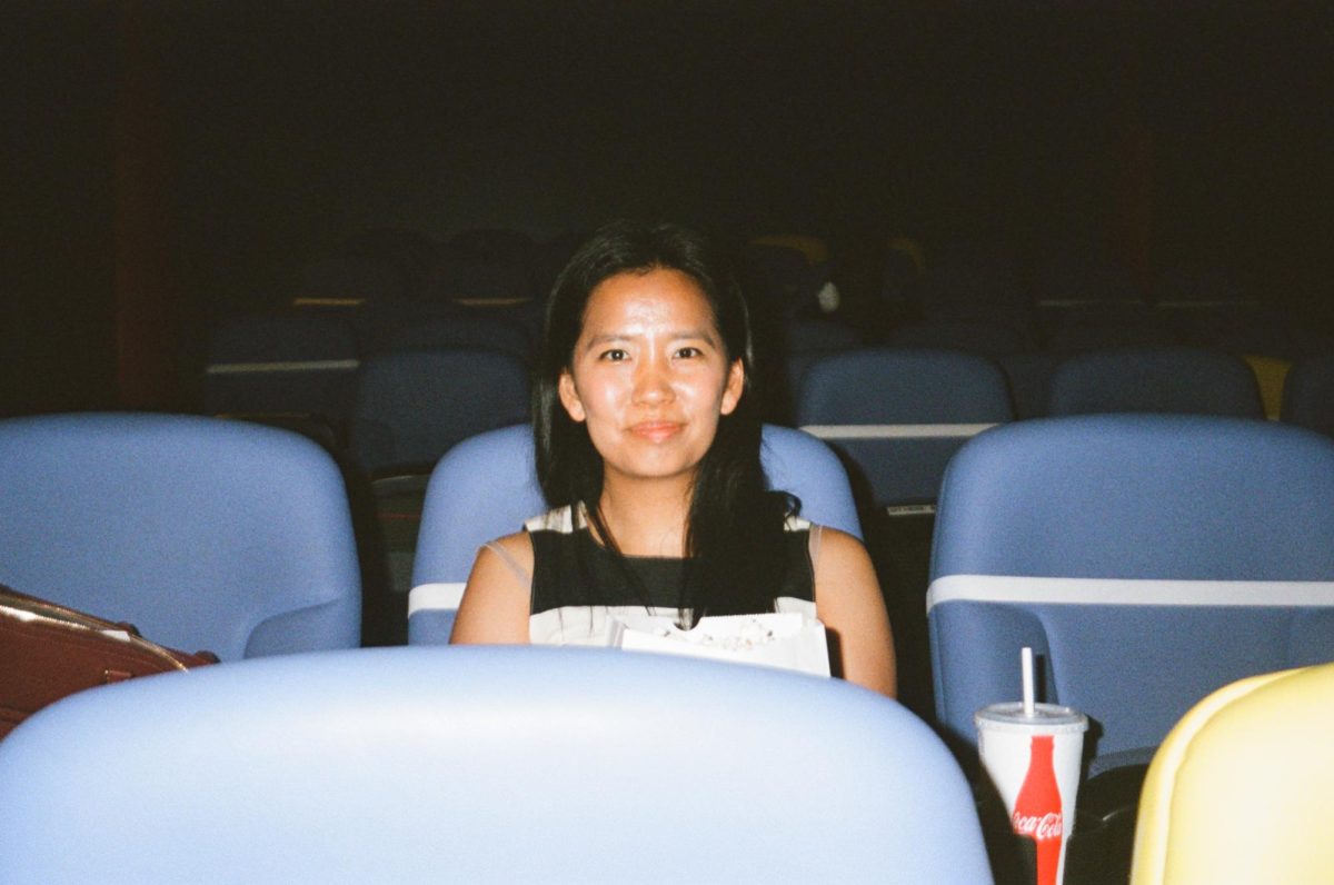 Taken in a film camera at Film Forum by her husband, Lauren is in a small repertory movie theater in the West Village– one of her favorite places in New York City. 