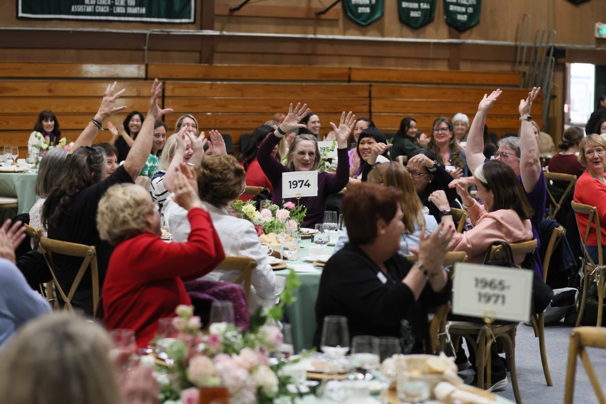 Westridge alumnae raise their hands to represent their graduating year during the luncheon.

