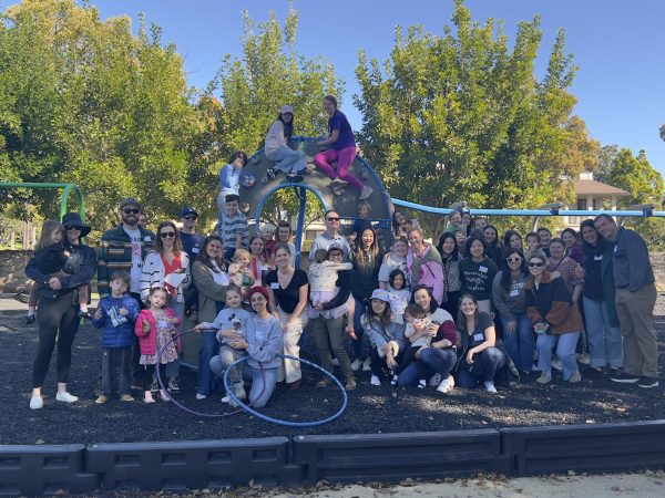 Over 50 attendees pose for a group photo at the playground structure after the two hour event.