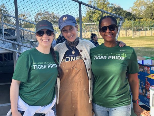 Booster Club Co-Chair Ms. Vanessa Withers, Mrs. Allison Dietrick, and Co-Chair Ms. Angela Rashid stand in front of their “Tiger Treats” table. “Parents, players, and fans are excited about [“Tiger Treats”] because it kind of makes Westridge athletics more of a thing,” said Mrs. Dietrick.