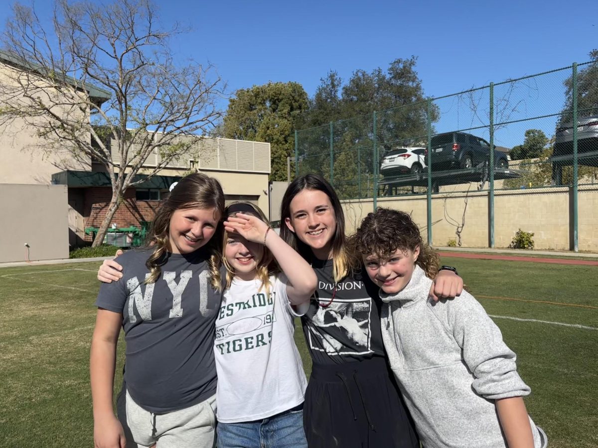 6th graders (Cassie D., Alexa S., Zetta G., and Lucy L.) smile for a photo while eagerly awaiting to race through the dinosaur-themed obstacle course.
