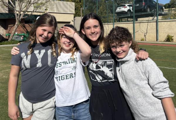 6th graders (Cassie D., Alexa S., Zetta G., and Lucy L.) smile for a photo while eagerly awaiting to race through the dinosaur-themed obstacle course.
