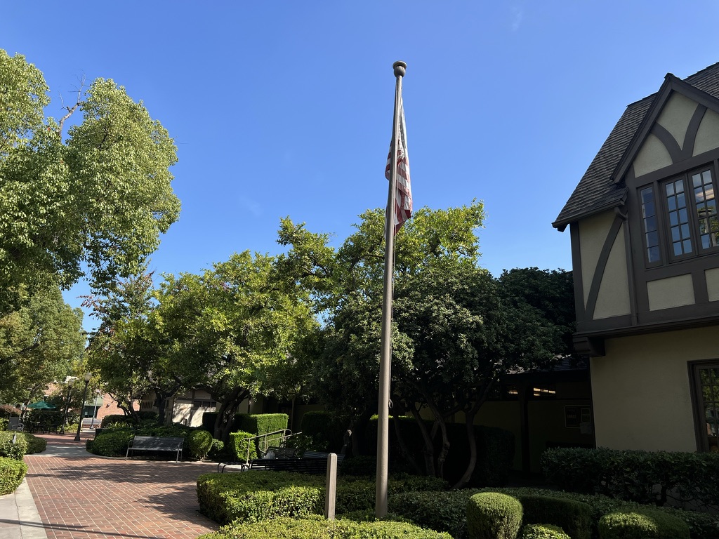 An old, sun-bleached American flag hangs in front of the Main Hall building.  