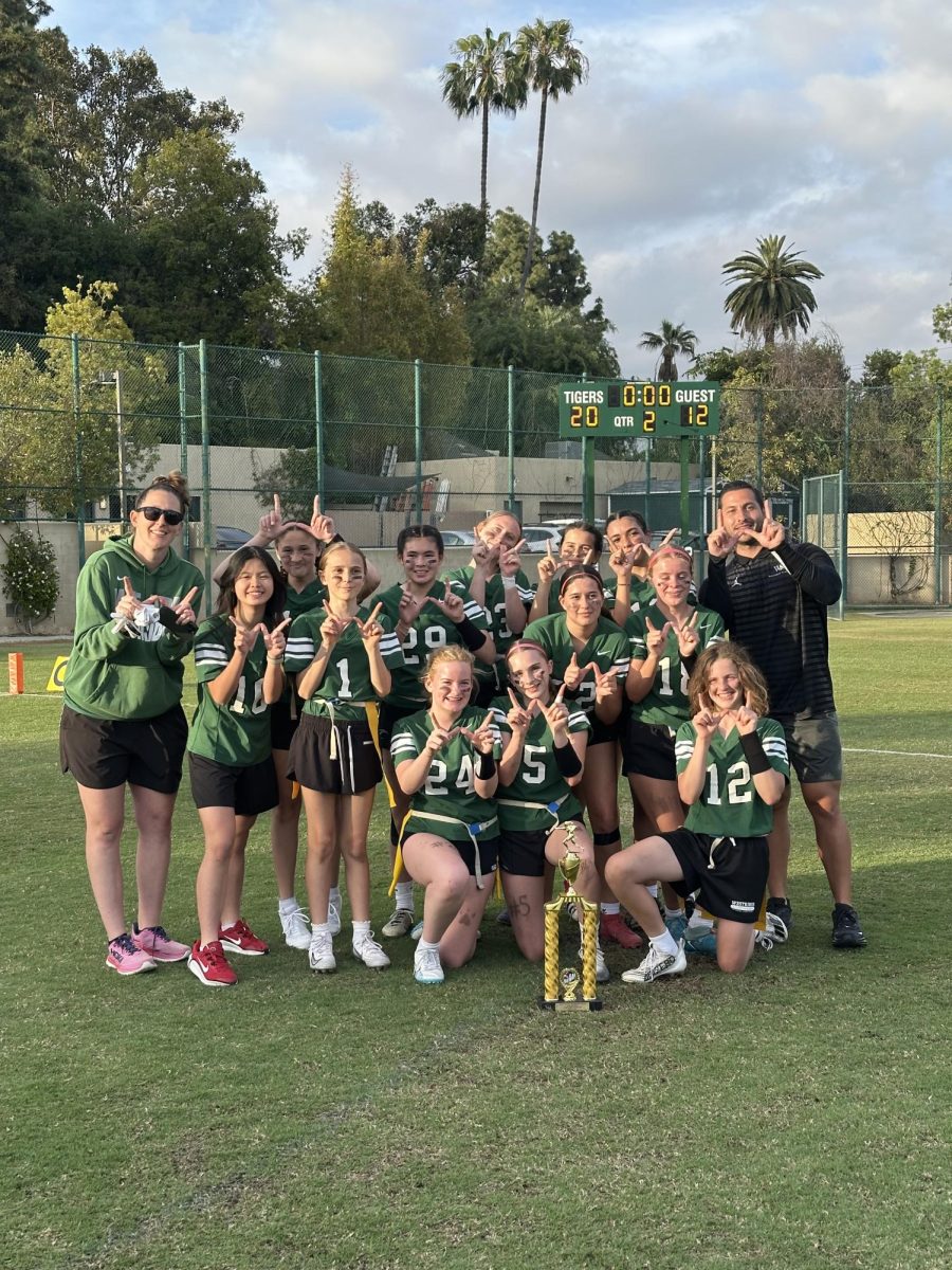The Middle School Flag Football team, Coach Nick, and Coach Allison posing with the championship trophy after winning the Independent Middle School League title. 