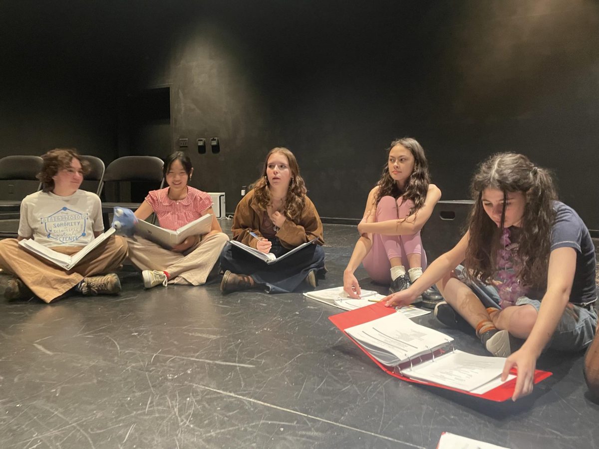 Cast members of Freaky Friday sit in a circle as they read a scene from their scripts.