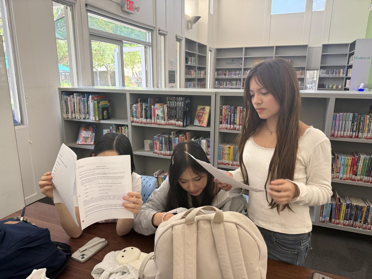 Sophomores Liv C., Jieni L., and Agnes P. absorb the contents of Jane Goodall’s personal essay. 
