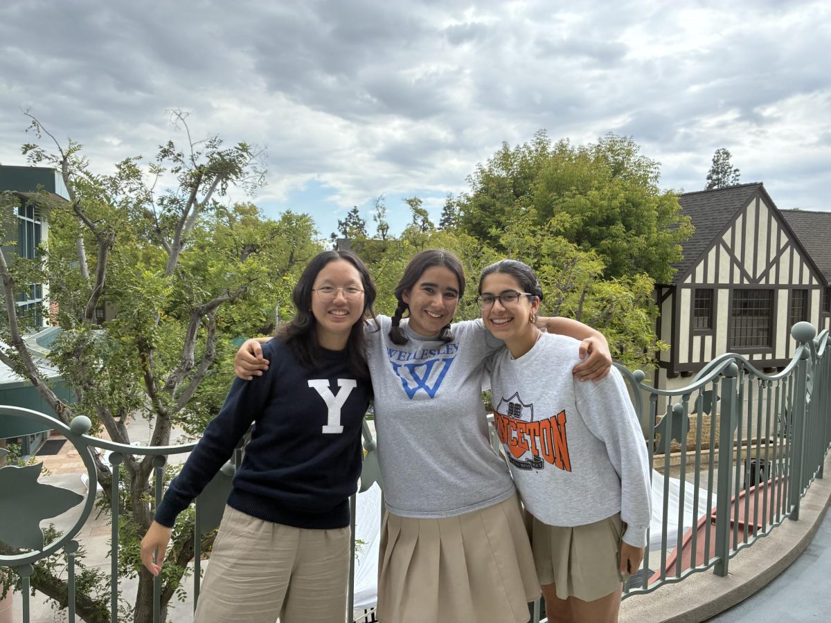 Three of the four seniors of the Spyglass Class of 2026 wearing their college merchandise.