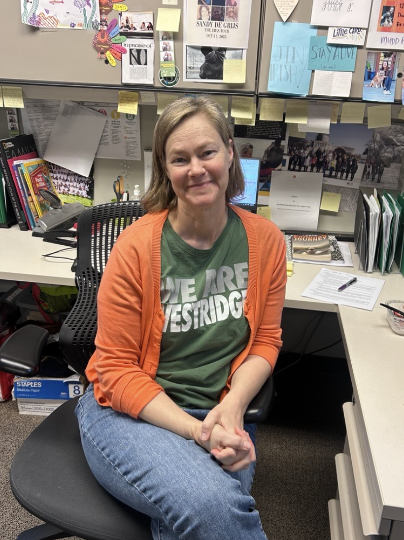 Ms. Irish poses at her desk in the office shared by the Cultural and American Studies teachers of the Middle School.